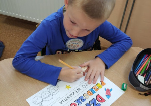 Uczeń wykonuje pracę plastyczną - Dyplom Przedszkolaka