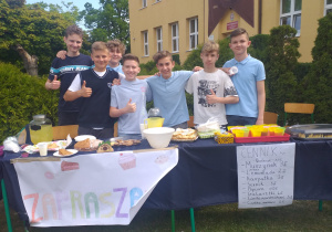 Uczniowie promują swoje stanowisko ze słodyczami.