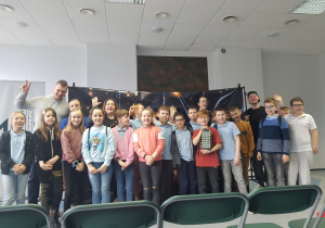 Zdjęcie grupowe uczniów z wychowawcą i organizatorami przedstawienia.