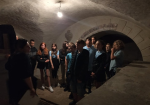 Uczniowie zwiedzają podziemia kościoła.