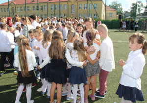 Uczniowie witają się z nauczycielem.