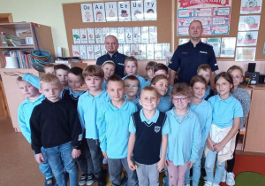 Uczniowie klas II pozują do zdjęcia z policjantami.