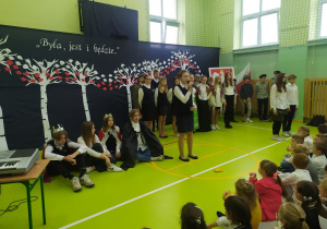 Uczennica śpiewa piosenkę patriotyczną.