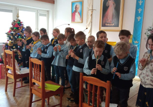 Uczniowie grają kolędy na flażoletach.