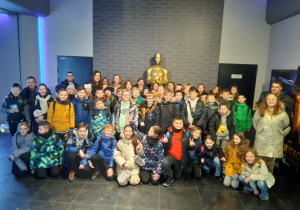 Uczniowie pozują do zdjęcia z " Oskarem" w kinie Helios.