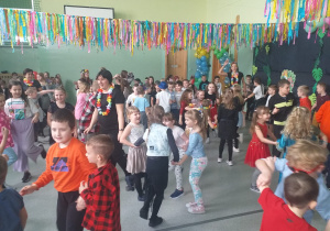 Uczniowie tańczą i bawią się na balu.