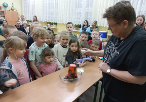 Dzieci obserwują doświadczenie z wulkanem.