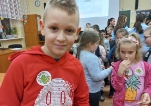 Dzieci prezentują otrzymane naklejki z logo szkoły.
