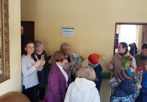 Uczniowie wręczają kwiaty pensjonariuszkom DPS-u