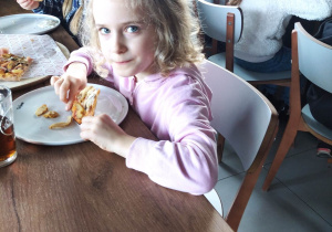 Dzieci jedzą wykonane przez siebie pizze.