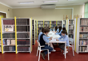 Uczniowie studiują wybraną literaturę.