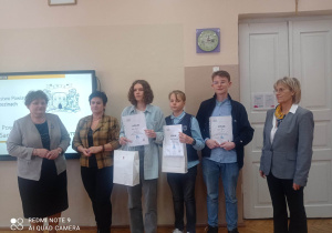 Uczniowie wraz z organizatorami konkursu pozują do zdjęcia.