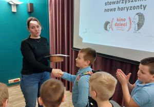 Dyrektor domu kultury wręcza dyplom uczniowi.