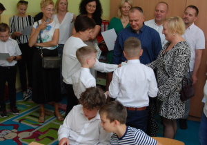 Wychowawca klasy trzeciej rozdaje podziękowania dla rodziców.
