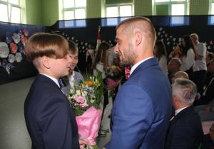 Uczeń składa podziękowania dyrektorowi i wręcza mu kwiaty.