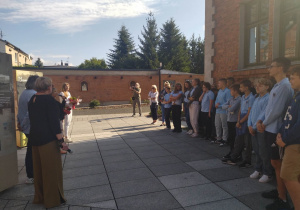 Uczniowie słuchają przemówienia dyrektora muzeum i innych zaproszonych gości.