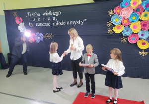 Uczennica wręcza "Oskara" nauczycielowi.