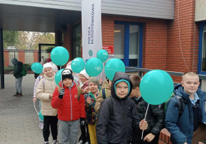 Uczniowie pokazują otrzymane w prezencie balony.