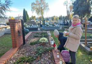 Uczniowie palą znicze na mogile poległych żołnierzy.