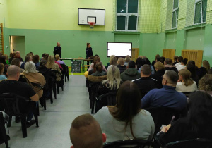 Policjanci prowadzą prelekcję na temat zagrożeń związanych z narkotykami.