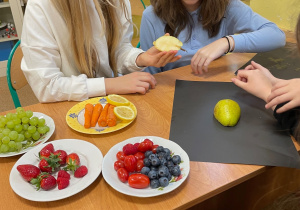 Uczniowie przygotowują pracę plastyczno - techniczną z owoców i warzyw.