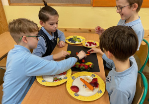Uczniowie przygotowują pracę plastyczno - techniczną z owoców i warzyw.