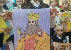 Uczennica prezentuje wykonany przez siebie portret Kazimierza.