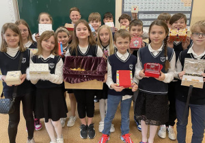 Uczniowie prezentują wykonane szkatułki.
