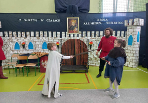 Uczniowie biorą udział w pokazie rycerskim.