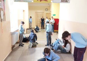 Uczniowie sterują robotami.