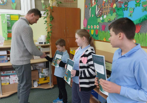 Nauczyciel wręcza dyplomy.