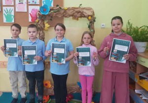 Uczniowie prezentują otrzymane dyplomy.