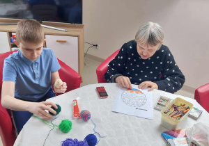 Uczniowie i seniorzy wykonują prace techniczne.