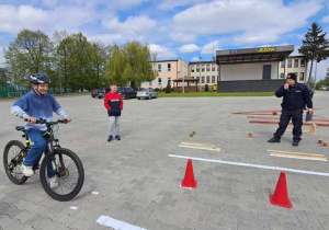 Uczeń wykonuje zadanie na rowerze.