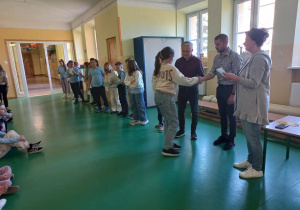 Dyrektorzy wręczają nagrody i gratulują wyróżnionym uczniom.