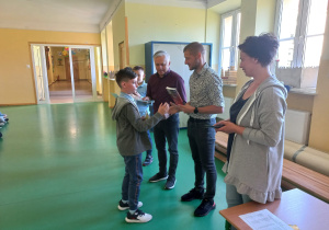 Dyrektorzy wręczają nagrody i gratulują wyróżnionym uczniom.