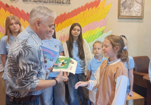 Dyrektor wręcza uczennicy nagrodę i dyplom.