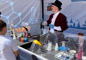 Uczniowie oglądają doświadczenia wykonywane przez chemika.