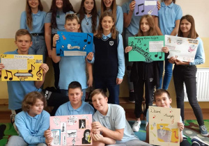 Grupa dzieci trzyma kolorowe plakaty przedstawiające wartości muzyczne