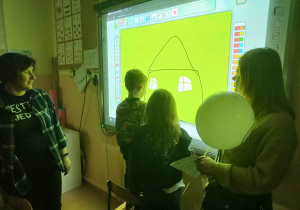 Dzieci malują obrazek na tablicy interaktywnej.